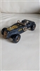 Handcrafted rough wooden HORNET car with a driver