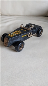 Handcrafted rough wooden HORNET car with a driver