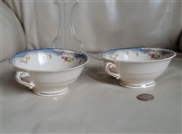 Pair of vintage 1950 Syracuse China Symphony footed cream soup bowls with double handles and a blue floral band on a cream porcelain body