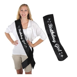 The Glittered Birthday Girl Satin Sash is black with Birthday Girl displayed in silver glittery writing. It is decorated with stars at both ends. Measures 33 inches long and 4 inches wide. One per package. No returns.