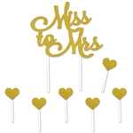 The Miss To Mrs Cake Topper is made of cardstock and printed on one side. Has gold glittered script lettering. Topper -4 in high and 4 1/2 in wide standing 8 1/2 in tall. Includes 6 1 in gold glittered hearts atop 31/2 stick. 7 pieces per package.