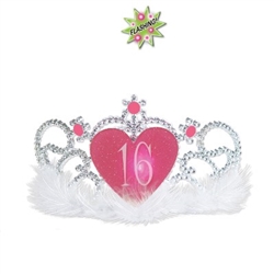 The Plastic Light-Up "16" Tiara is a standard sized silver tiara with soft white marabou feathers lining the headband. It has a glittery pink heart medallion with the number 16 printed in white lettering embellished with pink faux gems. No return