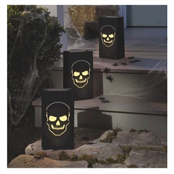 The Boneyard Luminary Bags feature a cutout design of a skull on the front of each black paper bag. Insert some sand to weigh down the bottom, and a battery operated candle to provide an eerie glow. Indoor or outdoor use. 6 luminary bags per package.